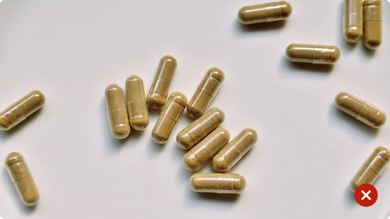 Brown capsules scattered on a white surface 