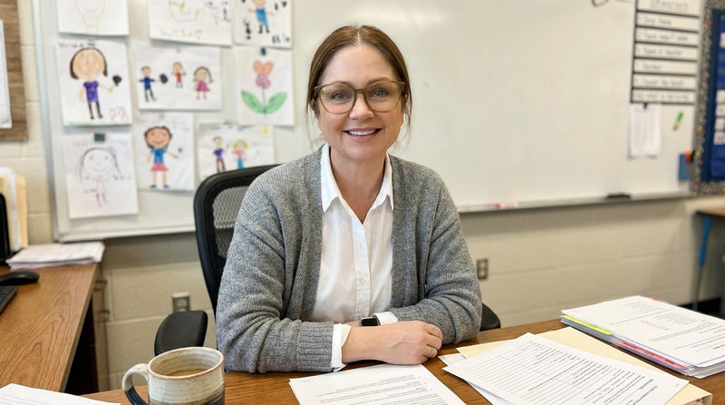 Teacher sitting at a desk in a classroom